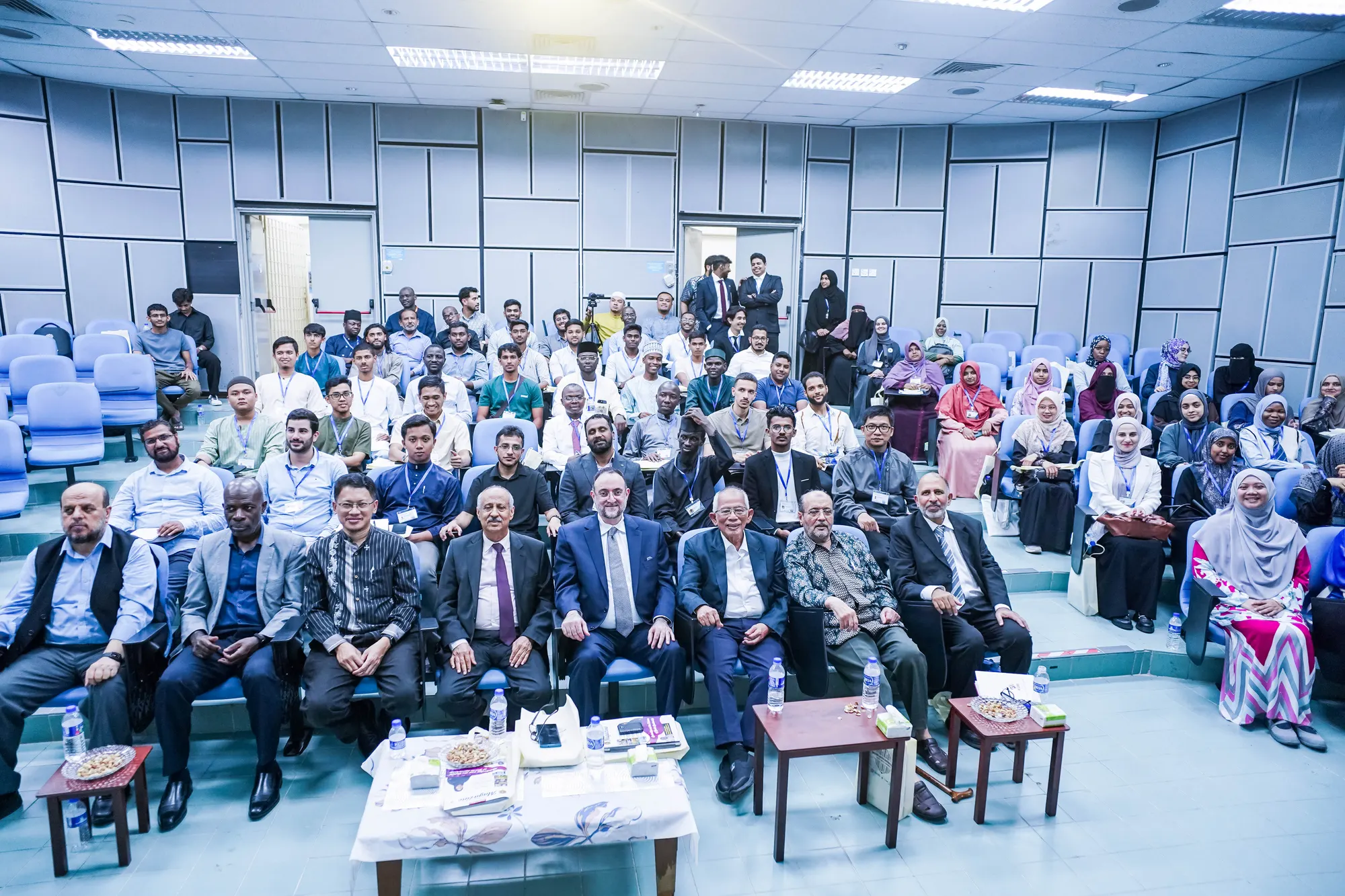 An audience of students and scholars seated in a lecture hall.